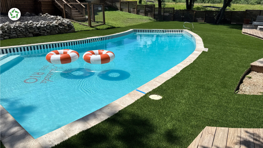 Curved backyard pool bordered by turf around the pool, a Lone Star Turf Texas project featured in Turf Around the Pool: Pavers vs. Concrete vs. Turf.