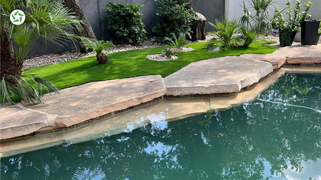 Stone pavers and turf around the pool in a landscaped Texas backyard, Lone Star Turf Texas, from Turf Around the Pool: Pavers vs. Concrete vs. Turf.