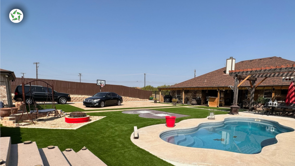 Freeform pool with concrete deck and turf lawn in a Central Texas backyard, Lone Star Turf Texas, Turf Around the Pool: Pavers vs. Concrete vs. Turf.