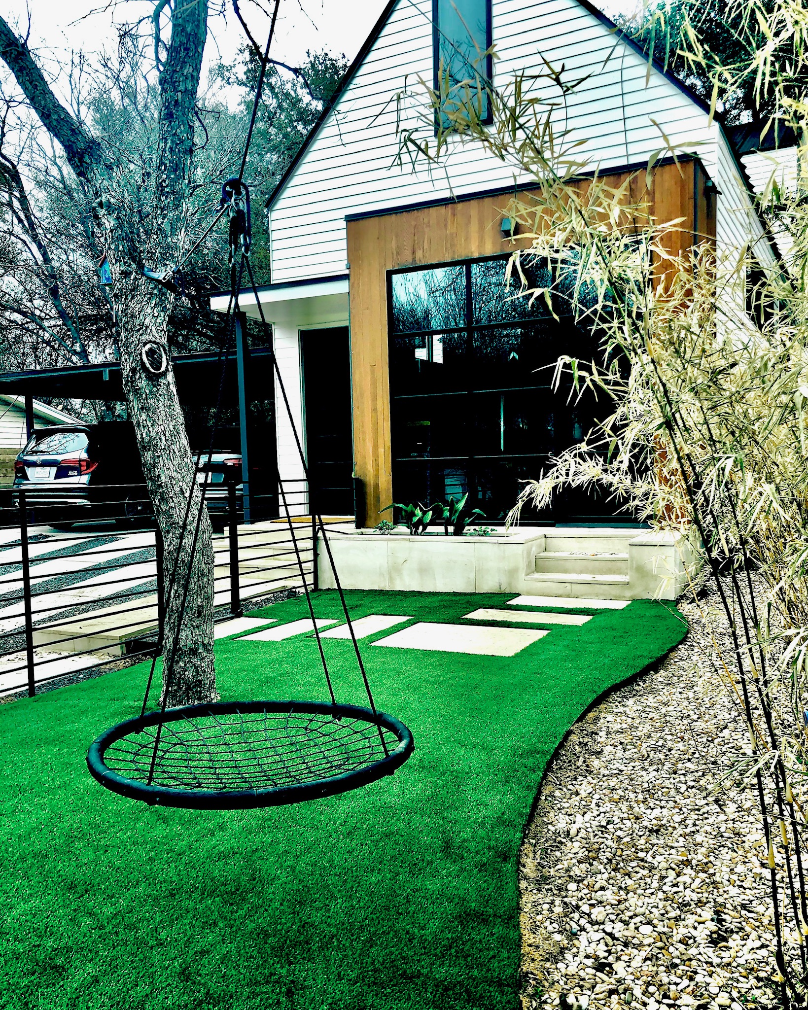 Yard with Tree Swing Backyard with artificial turf, pavers, and a tree swing