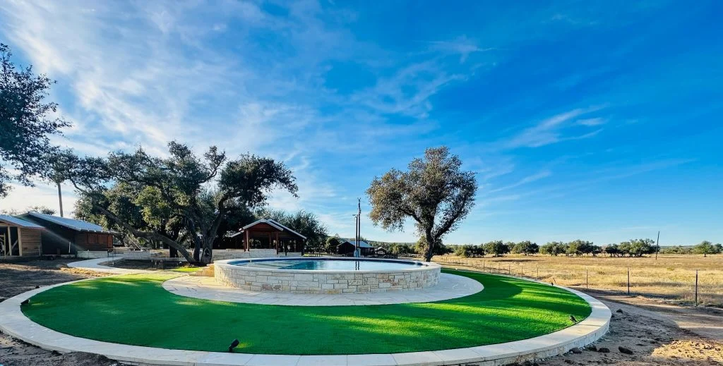 Artificial turf installed in a circle around a stone reflecting pool.