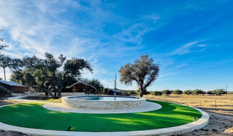 Artificial turf installed in a circle around a stone reflecting pool.