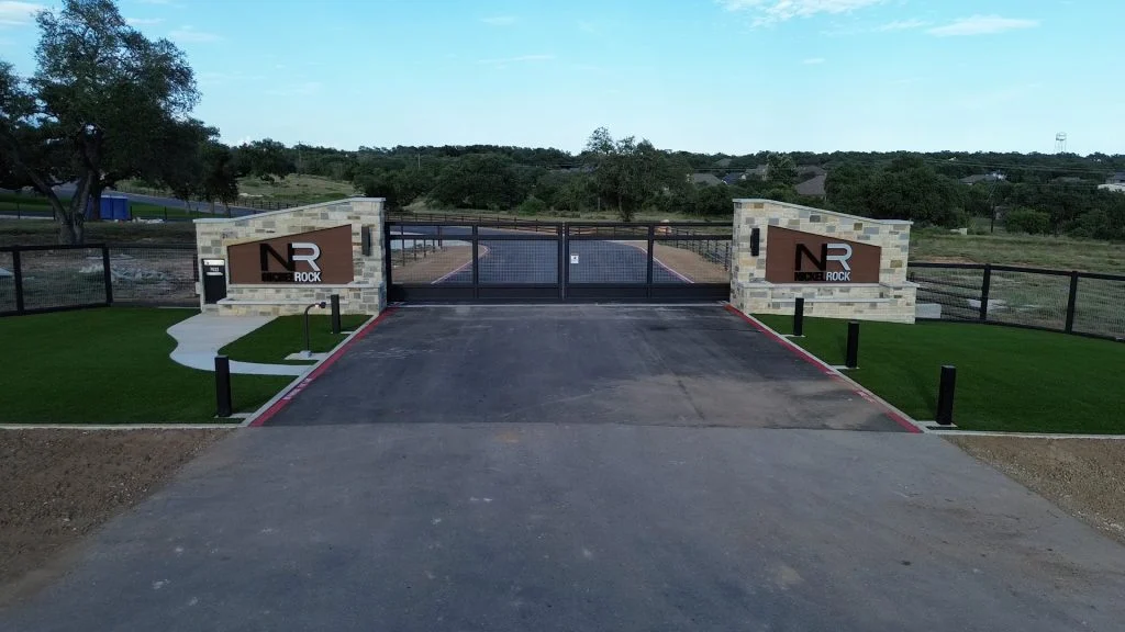 The entrance gate to Nickel Rock's new headquarters, with artificial turf installed to the left and right of the driveway.