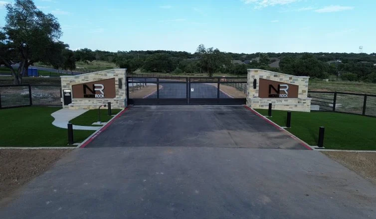 The entrance gate to Nickel Rock's new headquarters, with artificial turf installed to the left and right of the driveway.
