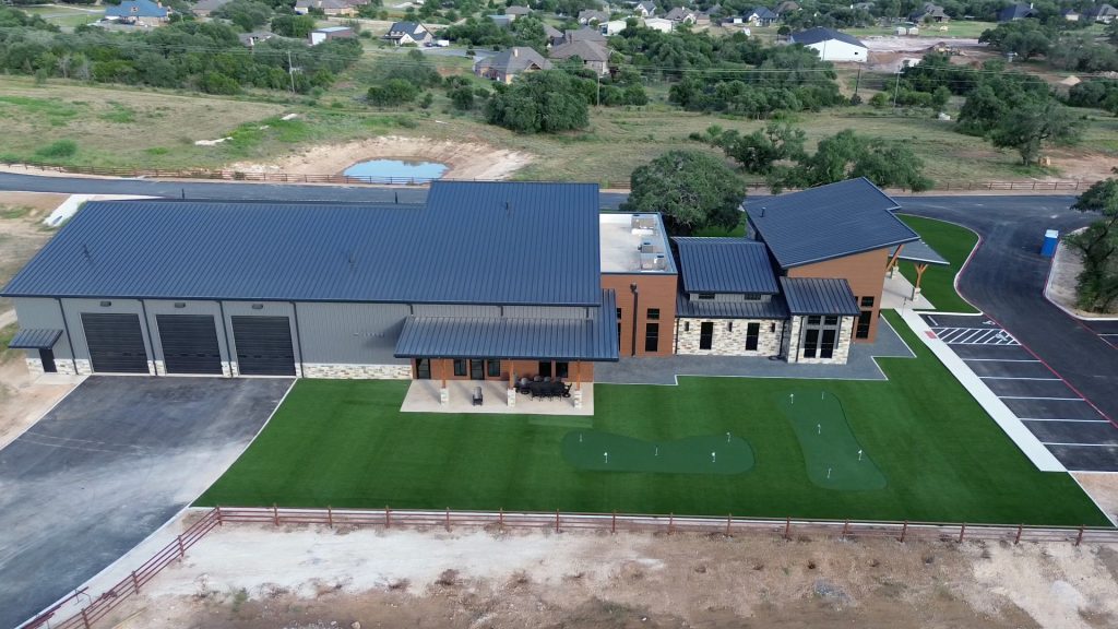 Aerial drone view of Nickel Rock HQ showing their new building and the surrounding grounds with landscaping artificial turf installed plus two putting greens.