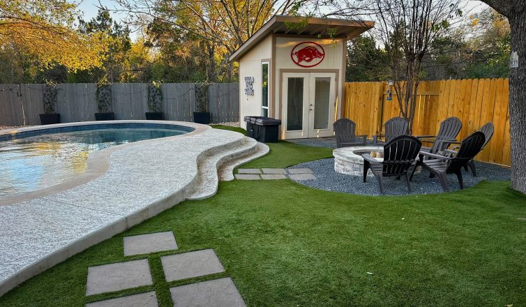 Low maintenance yard with artificial turf around a pool, fire pit, and shed.