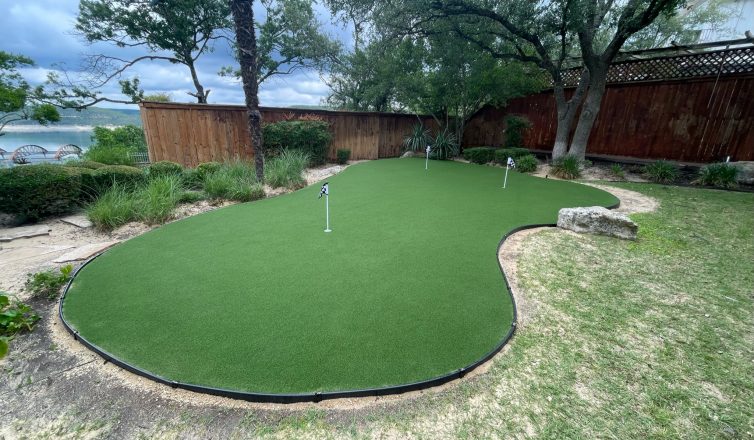Backyard putting green with 3 holes, in roughly the shape of a kidney bean.