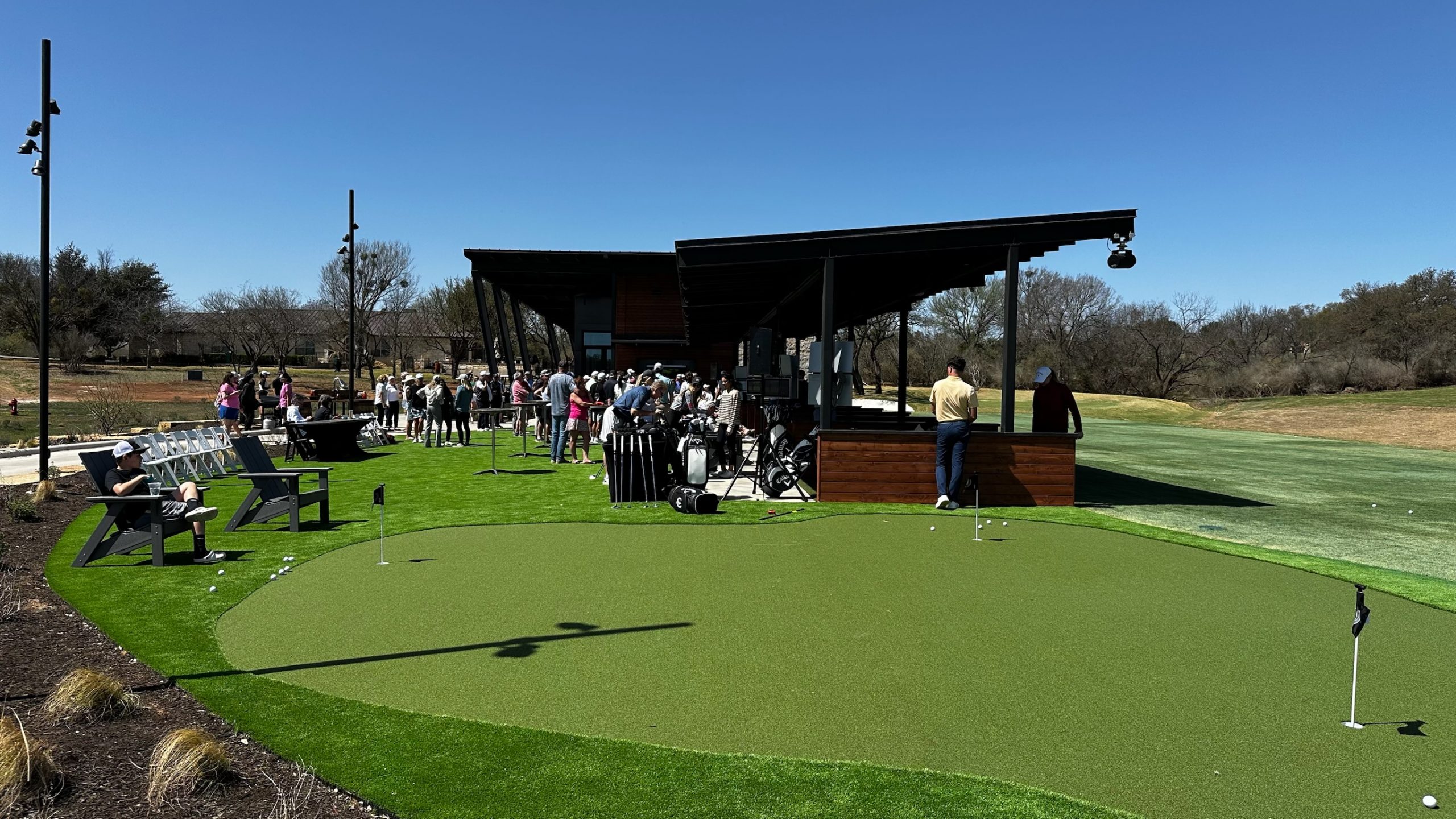 Img 4457 crowds gathered at a putting green and golf range with artificial turf installed