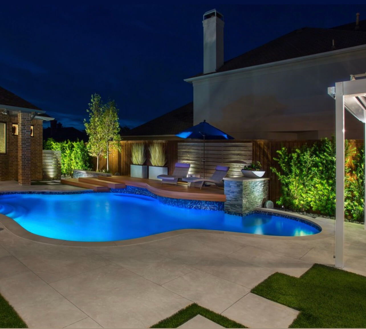 Outdoor lighting, accent lighting and uplight features around a pool in Texas