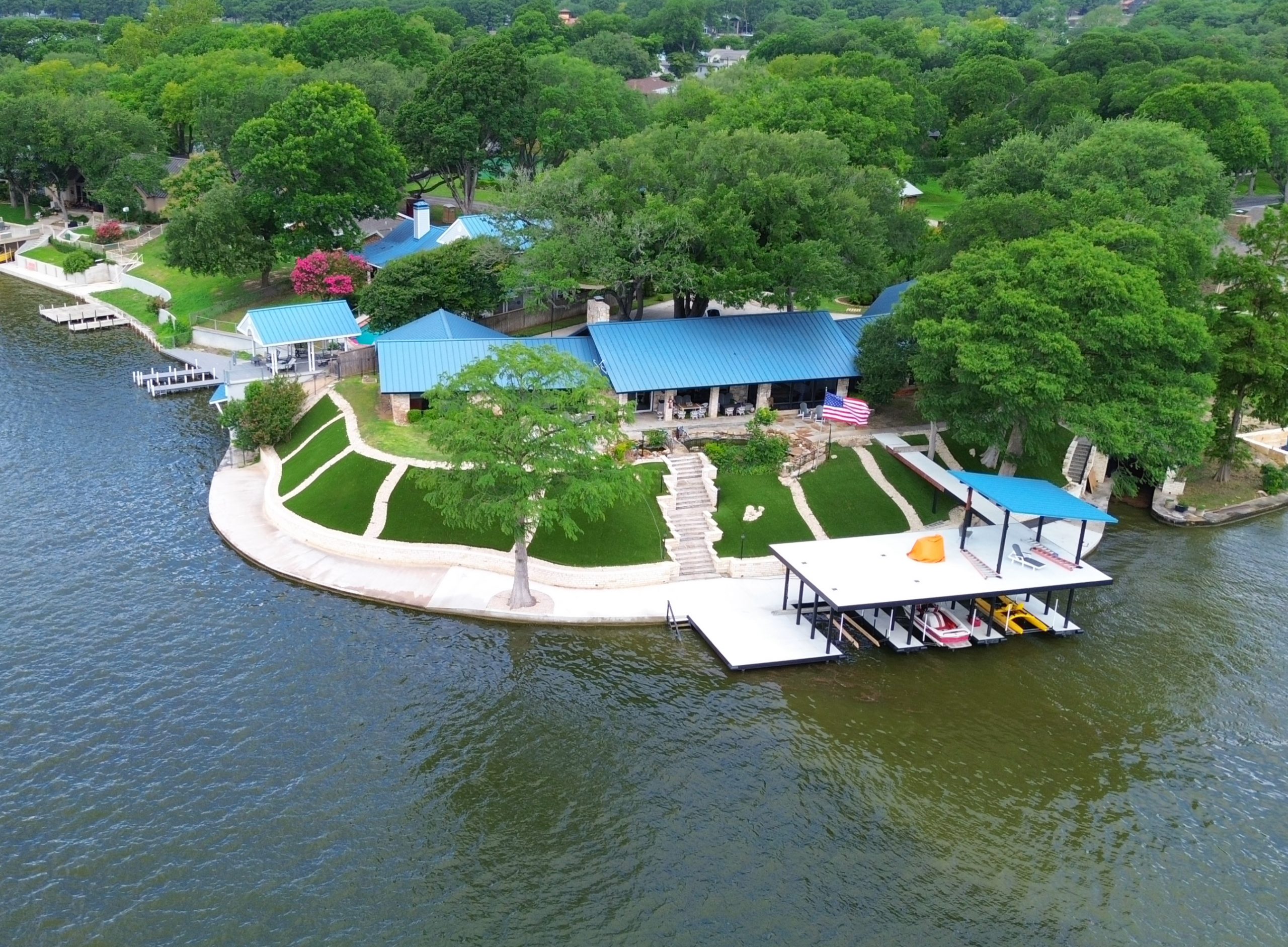 Aerial view of a lakefront Texas home with an artificial turf lawn installed by Lone Star Turf