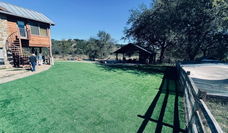Large backyard with beautiful and realistic-looking artificial turf installed.