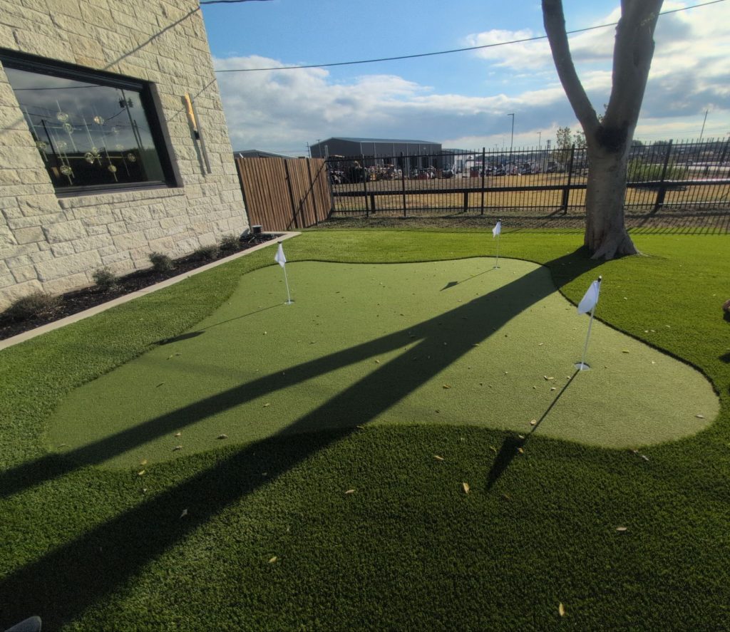 Custom artificial turf putting green with three holes.